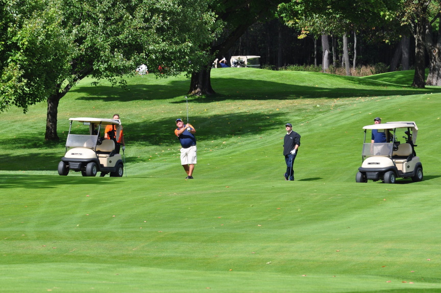 Golfers on the fairway with golf carts